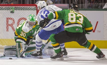 Hunter Skinner of the Knights tries to disrupt Mississauga's Nicholas Canade as he sweeps in on Brett Brochu in net for London during the first period of their game Friday night at Budweiser Gardens in London, Ont. 
Photograph taken on Friday January 3, 2020. 
Mike Hensen/The London Free Press/Postmedia Network