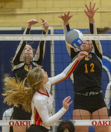 Sarah Ewan of Saunders tries for a tip over the combined blocks of Oakridge's Sarah Brule and Sydney Scatchard during their battle of the top teams at Oakridge secondary school Tuesday. (Mike Hensen/The London Free Press)