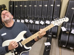 London library CEO Michael Ciccone lets out his inner rock star as the library gets ready to start lending out musical equipment including ukuleles, electric and acoustic guitars as well as amps and bases at the Central Library branch in London, Ont.  (Mike Hensen/The London Free Press)