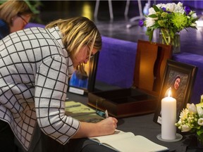 Louise Gloor Duncan, an associate director at Western, signs the books of remembrance Wednesday Jan. 15, 2020 before a memorial at Alumni Hall for four Western students who died when Ukrainian International Airlines flight PS752 was shot down in Iran Jan. 8. (Mike Hensen/The London Free Press)