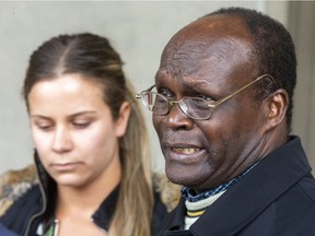 Amedeo Awai, father of slain Emmanuel Awai, speaks to reporters at the London courthouse on Thursday, Jan. 23, 2020, after the sentencing of his son's killer, William McDonald, while his son's girlfriend,  Rebecca Schlax, listens. (Mike Hensen/The London Free Press)