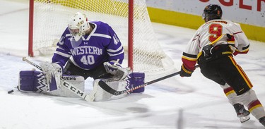 Western netminder Lucas Peressini gets a pad on Guelph Gryphon Mikkel Aagaard's in the first period of their Ontario university men's hockey game at Budweiser Gardens on Thursday, Jan. 30. The Mustangs posted a   5-4 win. (Mike Hensen/The London Free Press)