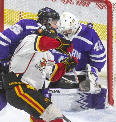 Western goalie Lucas Peressini gets lucky as the puck trickles over his shoulder and wide of the net as fellow Mustang Kyle Pettit tries to move Guelph's Ted Nichol away from the goalmouth in first-period Ontario university men's hockey action at Budweiser Gardens on Thursday, Jan. 30. Western won 5-4. (Mike Hensen/The London Free Press)