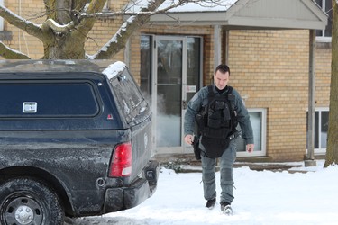 A London police officer leaves an apartment at 63 Wellington Rd., where city police assisted their Brantford counterparts in arresting homicide suspect Shajjad Hossain Idrish, 22, on Friday. DALE CARRUTHERS / THE LONDON FREE PRESS