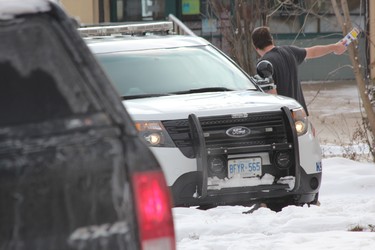 A man speaks with a London police officer near 63 Wellington Rd., where London police assisted their Brantford counterparts in arresting homicide suspect Shajjad Hossain Idrish, 22, on Friday. DALE CARRUTHERS / THE LONDON FREE PRESS