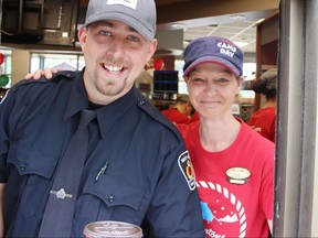 West Grey police Const. Cory Trainor, left, is shown in this file photo participating in a fundraiser at a Tim Hortons. Postmedia