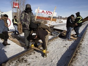 A protester tries to block counter protesters from tearing down a blockade at the CN rail line near 213 Street and 110 Avenue, in Edmonton Wednesday Feb. 19, 2020. Protester put up the blockade in solidarity with Wet'suwet'en Hereditary Chiefs. Photo by David Bloom
