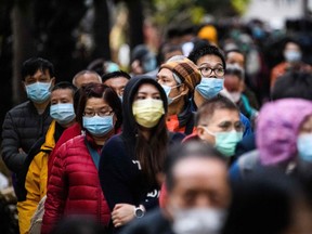 People wearing facemasks as a preventative measure following a coronavirus outbreak. (Photo by ANTHONY WALLACE/AFP via Getty Images)