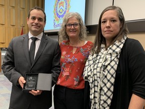 Det.-Const. Chris Adamovich received an award from the London Abused Women’s Centre on Thursday at the monthly police board meeting. The agency’s executive director, Megan Walker, centre, and staffer Jennifer Dunn, right, presented Adamovich with the citation. Dale Carruthers / The London Free Press