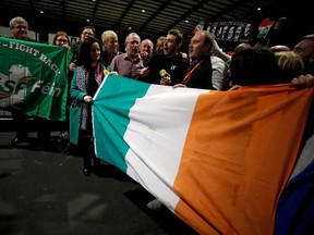 Sinn Fein supporters hold a national flag as votes are counted in Ireland's national election, in Dublin, Ireland, February 9, 2020. (REUTERS/Phil Noble/File Photo)