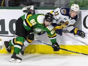 Emmett Sproule of the Erie Otters is pinned against the boards by Jason Willms of the London Knights during the third period of their game at Budweiser Gardens in London on Sunday January 19, 2020. (Derek Ruttan/The London Free Press)