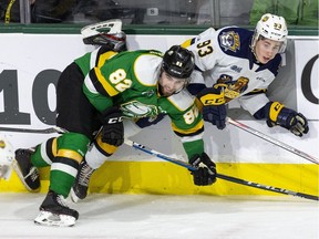 Emmett Sproule of the Erie Otters is pinned against the boards by Jason Willms of the London Knights during the third period of their game at Budweiser Gardens in London, Ont. on Sunday January 19, 2020. (Derek Ruttan/The London Free Press)