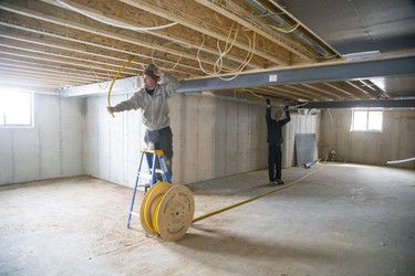 Tanner Dobson (left) and Ian McCallum install HVAC equipment in a home being built in the Woods Edge subdivision in Mt. Bridges. (Derek Ruttan/The London Free Press)
