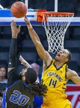 Mareik Isom of the London Lightning prevents a basket by Justin Moss of the Kitchener-Waterloo Titans during their National Basketball League of Canada game at Budweiser Gardens in London on Thursday. (Derek Ruttan/The London Free Press)