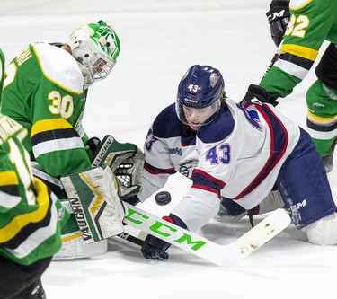 London Knight goalie Brett Brochu makes a save in front of Davis Codd of the Saginaw Spirit in London. Derek Ruttan/The London Free Press/Postmedia Network