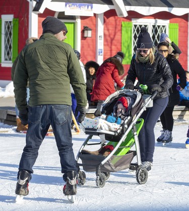 Evan and Julie Green take their 16-month-old daughter Abbie for a stroll on the skating rink in Victoria Park in London on Sunday February 16, 2020. Derek Ruttan/The London Free Press/Postmedia Network