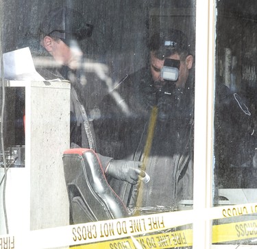 Investigators photograph evidence retrieved from a trash can inside Universal Kits barber shop at 920 Commissioners Road.The Ontario Fire Marshall, London Fire Department and London Police Department were investigating an explosion and fire inside a barber shop in London, Ont. on Monday February 17, 2020. The explosion occurred shortly after 12:00am Sunday morning.Derek Ruttan/The London Free Press/Postmedia Network