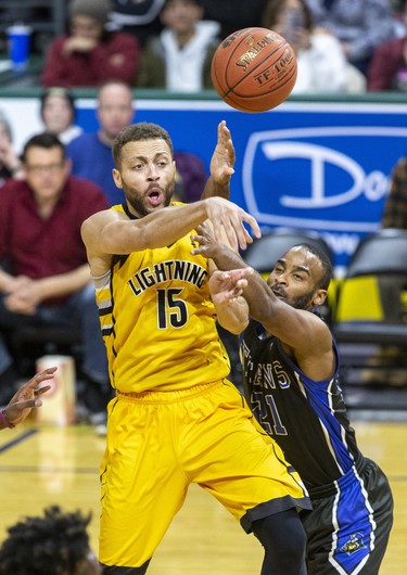 Garrett Williamson of the London Lightning passes to a teammate while covered by Akeem Scott of the Kitchener-Waterloo Titans during their game in London, Ont. on Monday February 17, 2020. Derek Ruttan/The London Free Press/Postmedia Network