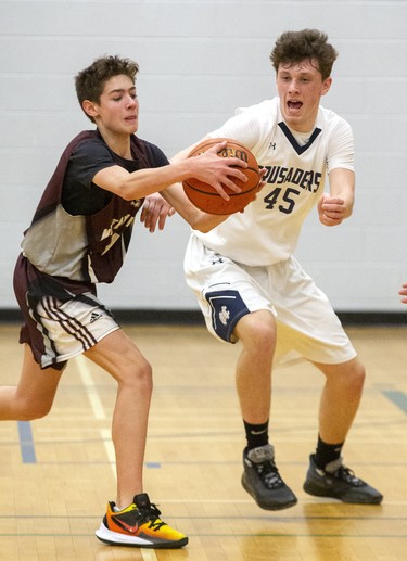 James Koch of Stratford Northwestern Secondary School catches a pass in front of Corson Skellett of Catholic Central High School during their WOSSAA "AAA" match at Sir Wilfrid Laurier Secondary School  in London, Ont. on Wednesday February 26, 2020. CCH won the game , 53-39. Derek Ruttan/The London Free Press/Postmedia Network