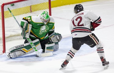 Keegan Stevenson of the Guelph Storm tucks the puck under the pad of London Knights goalie Brett Brochu to give the storm a 2-0 lead in the first period of their game in London, Ont.  Derek Ruttan/The London Free Press/Postmedia Network