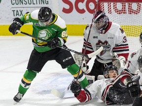 A point shot hits London Knight Jason Willms in front of Guelph Storm goalie Nico Daws and defenseman Fedor Gordeev during the first period of their game at Budweiser Gardens in London, Ont., Wednesday Feb. 26, 2020.  (Derek Ruttan/The London Free Press)