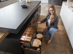 Corinna Haimerl shows a kitchen island featuring low drawers filled with utensils and tableware at Braam's Custom Cabinets in London. A group of home builders and renovators from the region are in London learning about designs suitble for people with mobility issues, including senior citizens. (Derek Ruttan/The London Free Press)