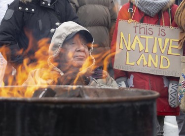 Aamjiwnaang First Nation elder Misquakeeshick sits near a fire barrel on the CP tracks at Waterloo Street and Pall Mall Street  in London, Ont. on Friday February 28, 2020. Approximately 300 people occupied the tracks in support of Wet'suwet'en hereditary chiefs. Aamjiwnaang First Nation is near Sarnia. Derek Ruttan/The London Free Press/Postmedia Network