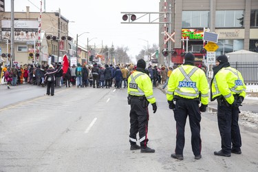 Police watch from a distance as protestors occupy the CP Rail tracks at Richmond Street where they stopped for fifteen minutes before continuing to the CP Rail tracks at Waterloo Street and Pall Mall Street  in London, Ont. on Friday February 28, 2020. The group of approximately 300 people occupied the tracks in support of Wet'suwet'en hereditary chiefs. Derek Ruttan/The London Free Press/Postmedia Network