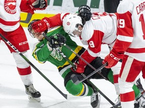 Jonathan Gruden of the London Knights gets mugged by Robert Calisti of the Soo Greyhounds during the first period of their game in London. (Derek Ruttan/The London Free Press)