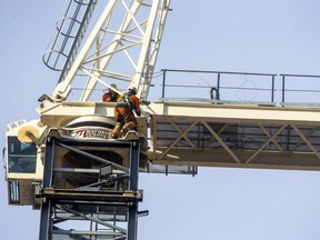 Workers from Oxford Cranes work more than 30 metres in the air as they assemble a new construction crane being erected at the site of the York Developments tower at 131 King St. across from the market in London. (Mike Hensen/The London Free Press)