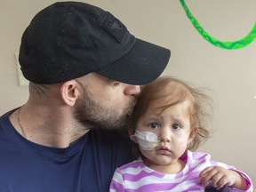 Lawrence Hill kisses his daughter Savannah Hill, 18 months old who needs a stem cell transplant for a rare form of leukaemia in London, Ont. Mike Hensen/The London Free Press)