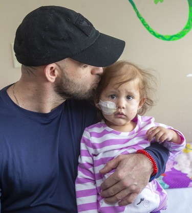 Lawrence Hill kisses his daughter Savannah Hill, 18 months old ,who needs a stem cell transplant for a rare form of leukemia in London. Mike Hensen/The London Free Press)