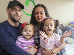 Lawrence Hill with his wife Jessica Rivera holds his daughter Savannah Hill, 18 months old as well as their other daughter Isabella, 2.5 years, who knows how to get a smile of her little sister. Savannah needs a stem cell transplant for a rare form of leukemia in London, Ont. Photograph taken on Monday February 3, 2020.