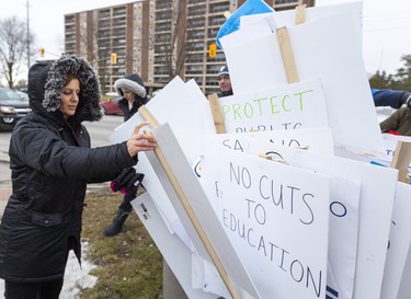 Nisreen Moussa from Westminster Secondary School grabs a sign out of a huge bin as teachers from Westminster SS, Saunders Secondary, Jean Vanier Catholic Elementary and Westmount Public School were picketing on Wonderland Road in London, Ont.. Photograph taken on Tuesday February 4, 2020.  Mike Hensen/The London Free Press/Postmedia Network