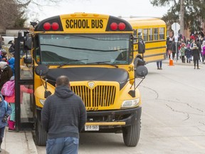 Hundreds of school aged children board buses ( 9 of them) or walk home with parents from Eagle Heights Public School in London, Ont.  Mike Hensen/The London Free Press/Postmedia Network