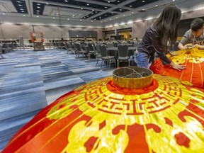 Co-chairs Vivian Iron and Alan Chan, of the Chinese Canadian National Council's London Chapter Dragon Festival assemble huge Chinese lanterns before they are lifted to the ceiling at the RBC Place London.  570 guests are expected Saturday night for the celebration of the Chinese New Year, with a charity component going towards El Sistema Aeolian. (Mike Hensen/The London Free Press)