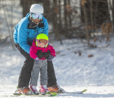 Mika Kueneman, 2, of London, gets a faster ride down the slopes with her dad Matt holding her upright at Boler Mountain on Sunday. Mike Hensen/The London Free Press/Postmedia Network