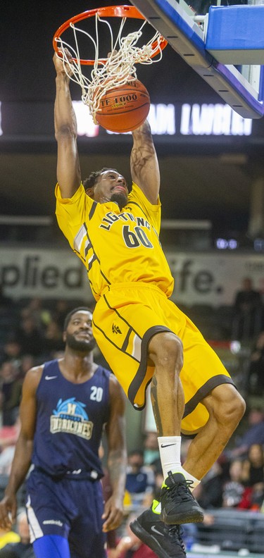 Marcus Capers of the London Lightning dunks with Halifax's Tremayne Johnson looking on during their Sunday afternoon game at Budweiser Gardens in London. 
Photograph taken on Sunday February 9, 2020. Mike Hensen/The London Free Press/Postmedia Network