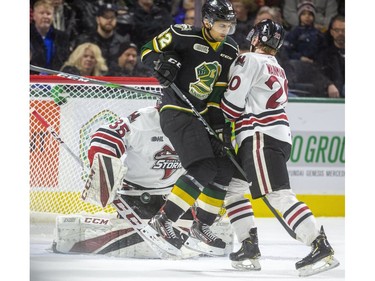 Sahil Panwar of the London Knights tries to screen Guelph Storm netminder Nico Daws while being checked by Josh Wainman during the first period of their game at Budweiser Gardens in London, Ont.  Tuesday Feb. 11, 2020.  Mike Hensen/The London Free Press