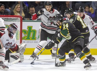 Luke Evangelista and Connor McMichael of the London Knights try to get the puck past Guelph netminder Nico Daws during the first period of their game at Budweiser Gardens in London, Ont.  Tuesday Feb. 11, 2020.  Mike Hensen/The London Free Press