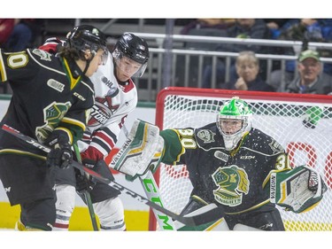 Antonio Stranges of the London Knights and Danny Zhilkin of the Guelph Storm tussle in front of  Brett Brochu in the net during the first period of their game at Budweiser Gardens in London, Ont.  Tuesday Feb. 11, 2020.  Mike Hensen/The London Free Press
