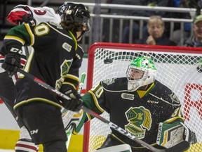 Antonio Stranges of the London Knights and Danny Zhilkin of the Guelph Storm watch a high shot from the Guelph point that nearly bounces in over Brett Brochu in the net during the first period of their game at Budweiser Gardens in London on Tuesday Feb. 11, 2020.  (Mike Hensen/The London Free Press)