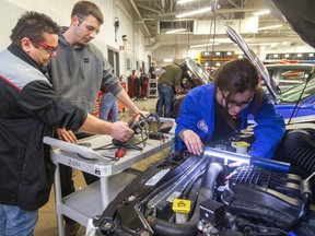 Mark Shulz(cct) of Exeter watches the engine scanner with instructorDave Vollmer as Mackenzie Burns of St. Thomas puts the lead on the engine's generator (previously called alternator.) The students were studying the computer controlled charging systems as part of their Level 3 technician program at Fanshawe's School of Transportation Technology & Apprenticeship in London, Ont.  (Mike Hensen/The London Free Press)