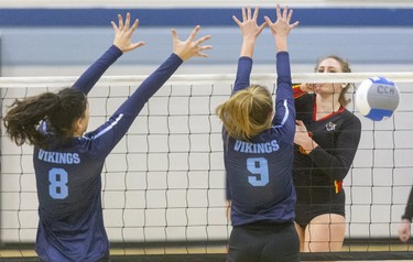 Saunders big hitter Aliah Admans hammers the ball down the line past the combined block of Lucas' Phanee Botetzayas and Nicole More during their WOSSAA AAA semi-final game at CCH in London, Ont.  Photograph taken on Tuesday February 25, 2020.  Mike Hensen/The London Free Press/Postmedia Network