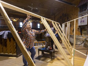 Gary Cook helps to lift a wall as the play must go on with a new set being built at the Purple Hill Country Hall near Thorndale. After a fire destroyed their community centre, this hall was offered as a replacement with the first performance to be Friday night. (Mike Hensen/The London Free Press/Postmedia)