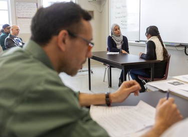 Yasmin Zaaroory gets interviewed for a job by fellow student and interviewer Mahboba Zazia as student Luis Herney Melo reviews his own notes during an English as a Second Language. They are students at an English as a Second Language program at the Centre for LIfelong Learning on King Street in London, Ont.  Students take turns interviewing and answering questions to prepare them for job interviews. Teacher Maria Karidas says the project is fun, but also teaches writing, reading and speaking skills. Photograph taken on Thursday February 27, 2020.  Mike Hensen/The London Free Press/Postmedia Network