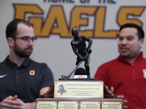 This week was the 34th edition of a Kingston sporting tradition: Queen's University assistant coach Spencer Abraham, left, and Royal Military College Paladins coach Richard Lim are pictured with the Carr-Harris trophy, which the two school teams battled over, on Thursday. Ian MacAlpine/Postmedia