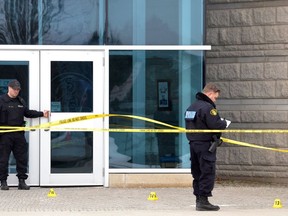An officer with the OPP Forensic Identification Unit documents evidence just outside the front entrance to Little Falls Public School in St. Marys Wednesday afternoon. Galen Simmons/The Beacon Herald/Postmedia Network
