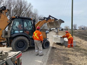 Crews move concrete blocks on Erie Shore Drive, which was closed to traffic on Monday to facilitate dike repairs. (Handout)
