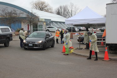 Healthcare workers screen people outside Oakridge arena, where London's first COVID-19 assessment centre opened this week. (MEGAN STACEY/The London Free Press)